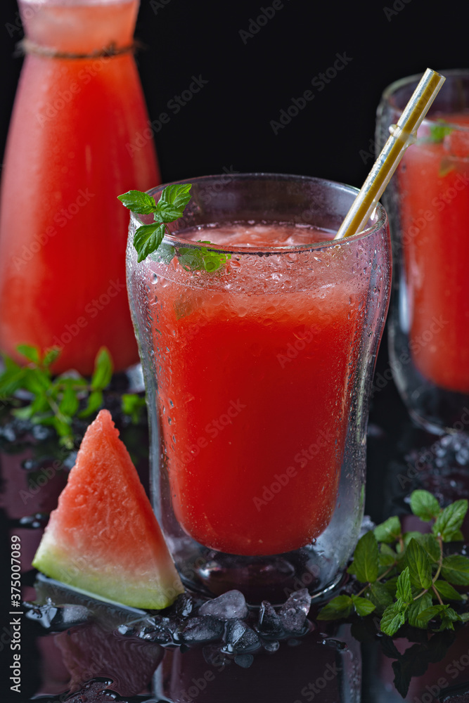 Summer cold drink with watermelon and mint on a black wooden background. Copy space. Summer cold drink with watermelon and mint on a black wooden background. Copy space.