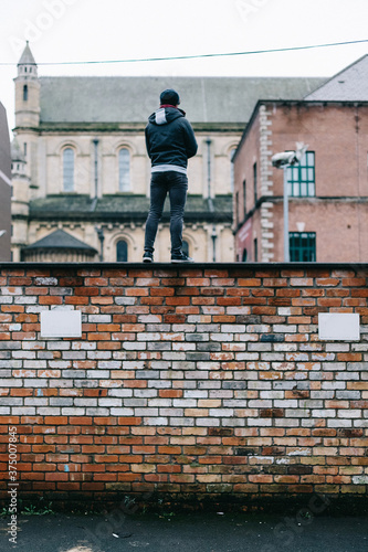 Wallpaper Mural Young Man Standing on a High Wall in the City Torontodigital.ca
