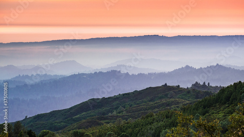 Sunset views in Santa Cruz mountains; Smoke from the nearby burning wildfires, visible in the air and covering the mountain ridges and valleys; South San Francisco Bay Area, California