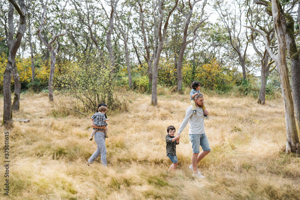 Fun loving family of five walking together in grassy nature. Fun loving family of five walking together in grassy nature.
