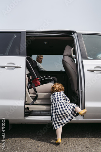 Little girl climbing into minivan