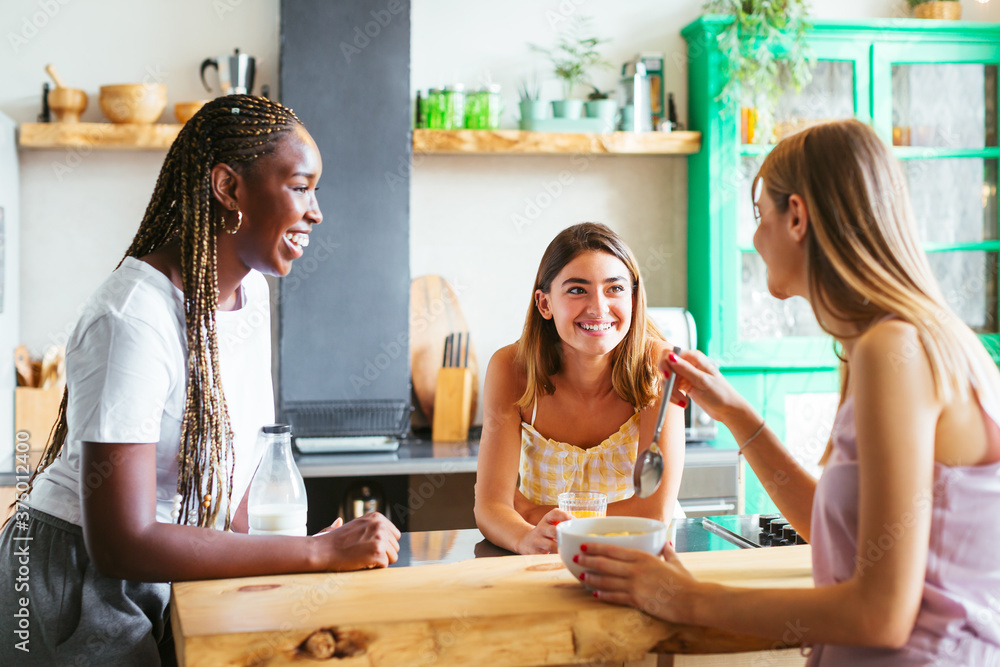 Cheerful diverse teenagers gossiping during breakfast Cheerful diverse teenagers gossiping during breakfast