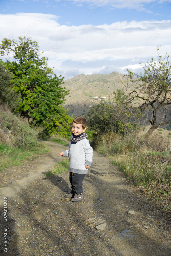 Little boy walking on a path in the countryside Little boy walking on a path in the countryside