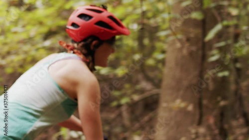 A woman mountain biking through the woods 