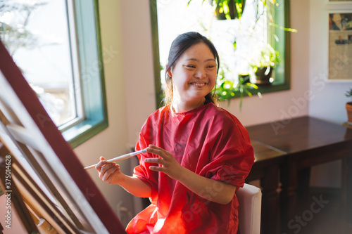 Young woman painting at home.