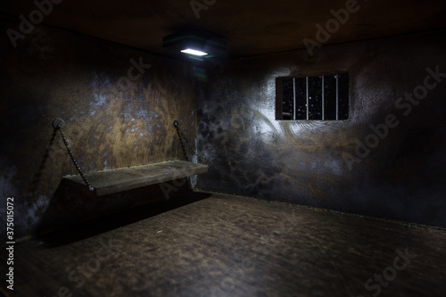 Jail or prison cell. Old grunge prison miniature. Dark prison interior creative decoration. Empty cell. Selective focus Obsolete gray grunge concrete room. photo