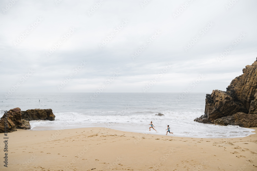 Kids running, playing and enjoying empty beach and ocean waves. Kids running, playing and enjoying empty beach and ocean waves.
