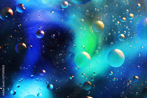 Oil bubbles floating in colored water - Macro photo