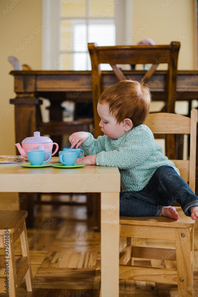 Toddler baby with red hair playing and using her imagination at Toddler baby with red hair playing and using her imagination at