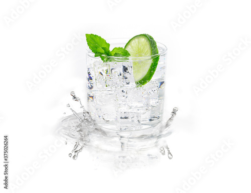 Isolated on white background glass of mojito garnished with mint and lime splashing water on reflecting surface