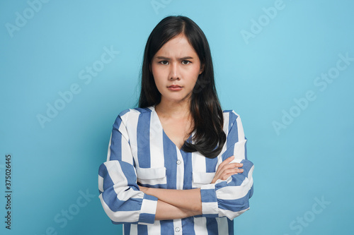 An angry woman standing with her arms folded photo