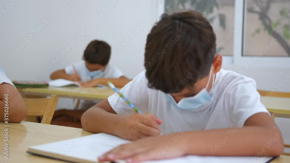 School Boys In Classroom Wearing Face Masks Taking A Quiz Rack Focus To Boy In Back School Boys In Classroom Wearing Face Masks Taking A Quiz Rack Focus To Boy In Back