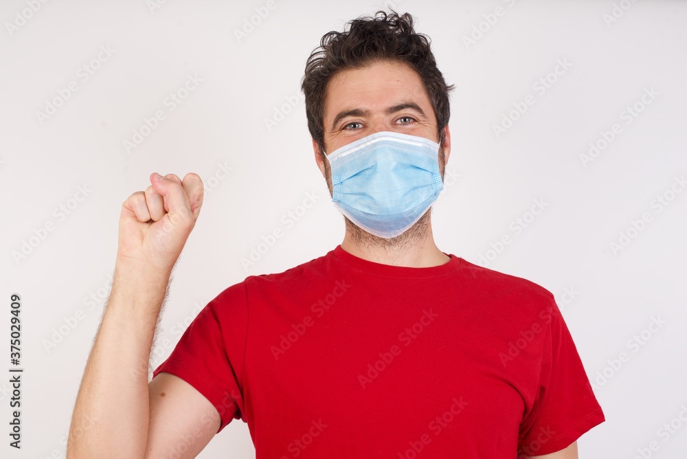 Young caucasian man with short hair wearing medical mask standing over isolated white background pointing up with fingers number ten in Chinese sign language Shi Young caucasian man with short hair wearing medical mask standing over isolated white background pointing up with fingers number ten in Chinese sign language Shi