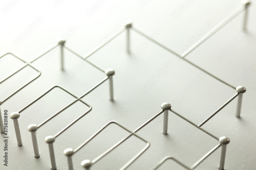 Hierarchy, command chain, company / organization structure or layer and grouping concept image. Top down structure made from chrome wires and silver nails and wire on white. Shallow depth of field. - obrazy, fototapety, plakaty 