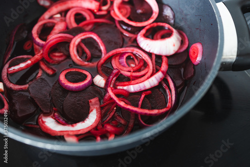 simple food ingredients, red onion rings and slices of beetroot on pot on kitchen stovetop