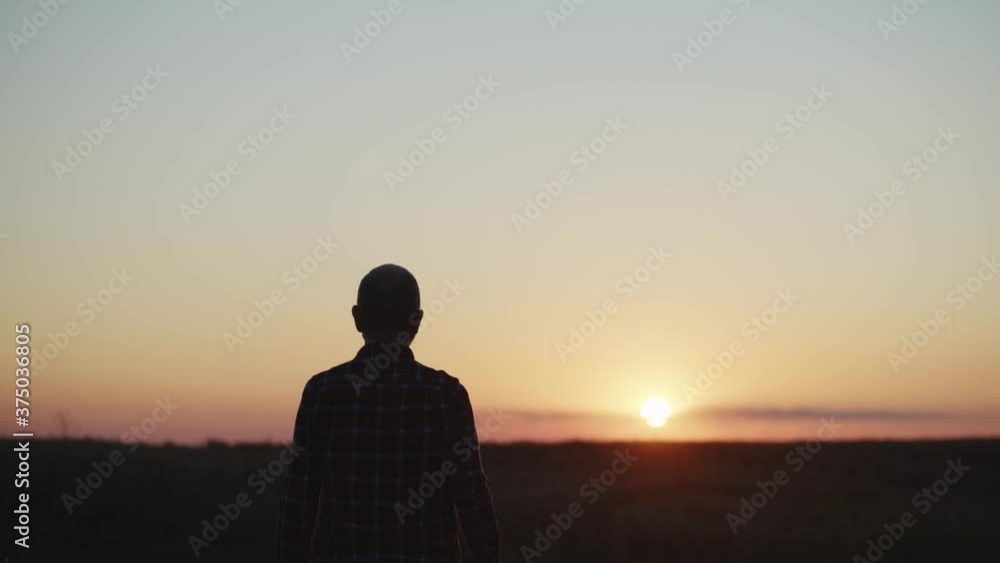 Silhouette of man at sunset sky. Emotional scene. Unrecognisable traveling male person enjoying the beauty of setting sun in summer evening time. Human aging concept. Fantastic landscape view. 4K Silhouette of man at sunset sky. Emotional scene. Unrecognisable traveling male person enjoying the beauty of setting sun in summer evening time. Human aging concept. Fantastic landscape view. 4K