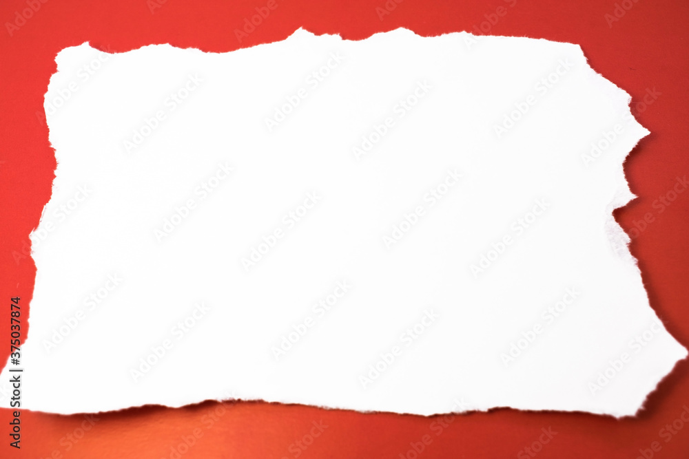 a white torn sheet of paper with space for text lies horizontally on a red background a white torn sheet of paper with space for text lies horizontally on a red background