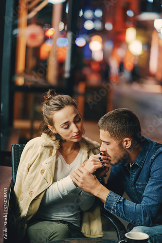 couple drinking coffee outside a restaurant at night