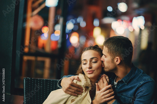 couple drinking coffee outside a restaurant at night