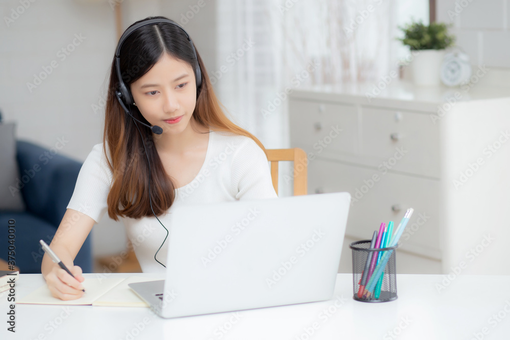 Young asian woman wearing headphone study online with e-learning on desk, girl wearing headset learning to internet with laptop computer at home, new normal, distance education and training. Young asian woman wearing headphone study online with e-learning on desk, girl wearing headset learning to internet with laptop computer at home, new normal, distance education and training.