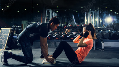 personal trainer to practice sit-ups in the gym