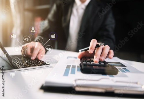 Female businessman working with holding a pen and using a calculator to calculate the numbers of static at home office. Finance accounting concept