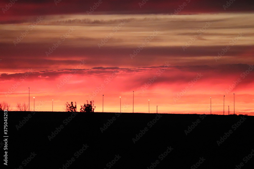 vibrant sunset silhouette on a shadowy prarie