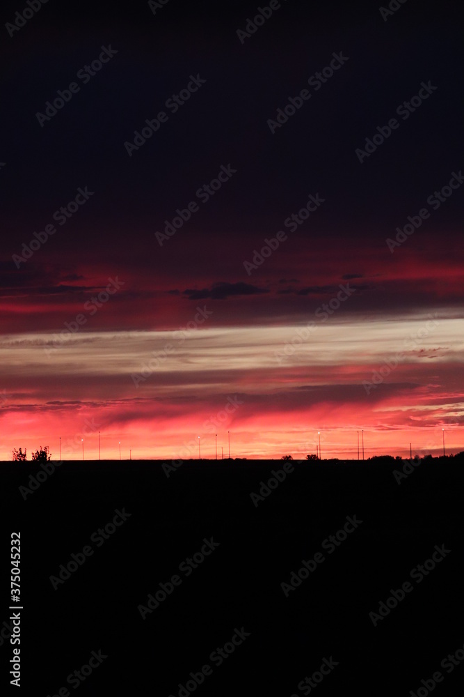 vibrant sunset silhouette on a shadowy prarie