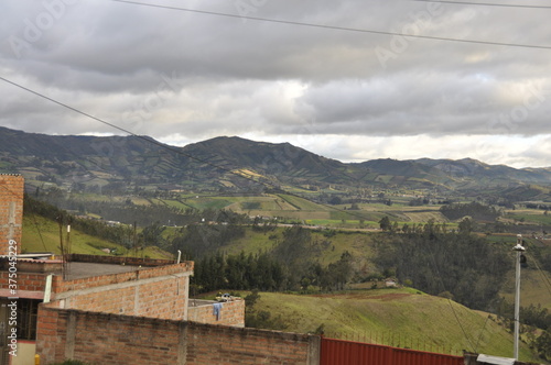 paisaje, ciudad, nubes, montañas, ciudad entre montañas, atardecer ciudad, luces, montañas verdes, matices de verdes, 
naturaleza. casas,  photo