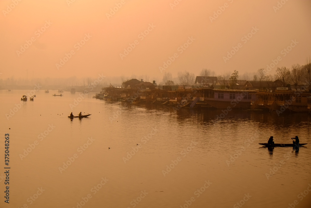 Boathouses and rowboats on Lake Dal in Srinagar, northern India.A smoky lake without wind is a mirror.