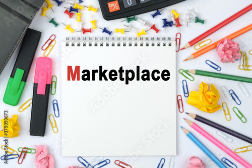 On the table is a calculator, diary, markers, pencils and a notebook with the inscription - Marketplace