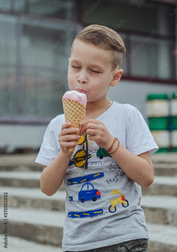 boy holding a large cone of creamy ice cream with fruit flavor boy holding a large cone of creamy ice cream with fruit flavor