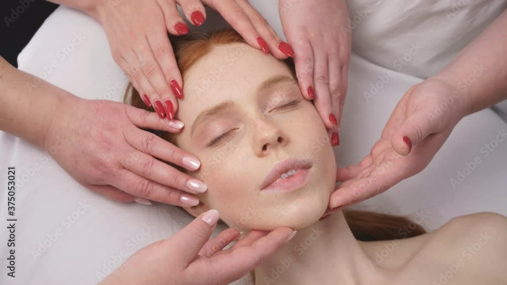 Close-up image of the face of a young woman who is surrounded by the hands of cosmetologists. Close-up image of the face of a young woman who is surrounded by the hands of cosmetologists.