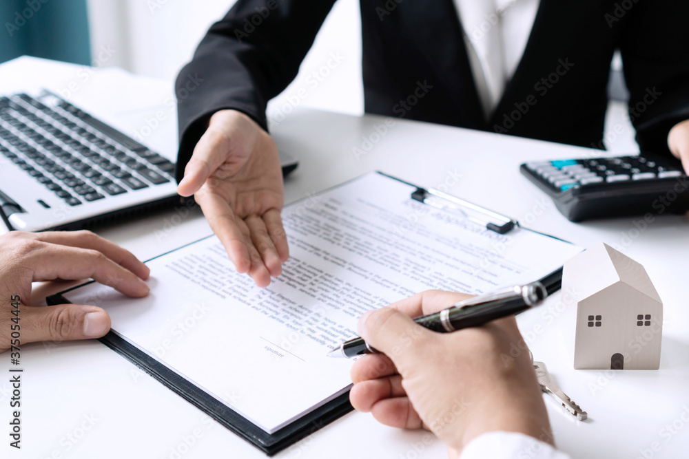 Client man is signing rental lease contrac or sale purchase agreement with female realtor of bank officer. Real estate, moving home, renting or buying property concept. Close-up. Client man is signing rental lease contrac or sale purchase agreement with female realtor of bank officer. Real estate, moving home, renting or buying property concept. Close-up.