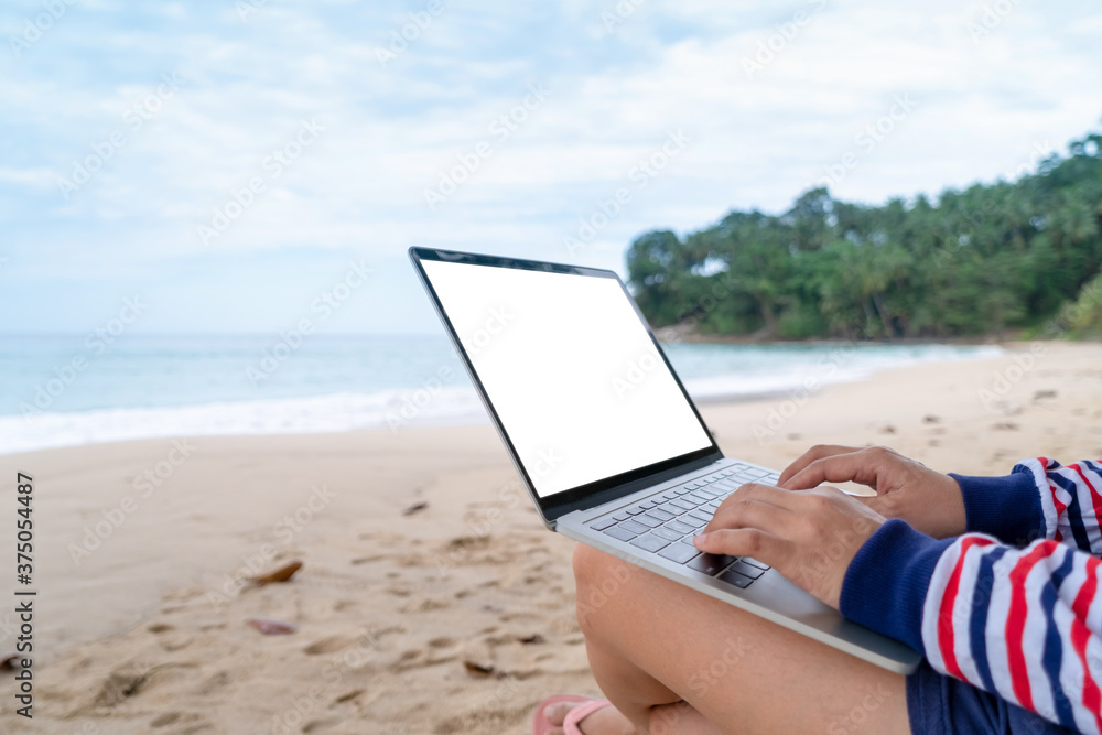Woman using laptop and smartphone to work study in vacation day at beach background.