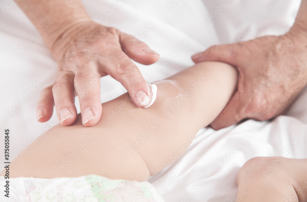 Grandmother applying body cream on her grandson. Grandmother applying body cream on her grandson.