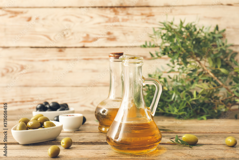 Jugs of olive oil on wooden table Jugs of olive oil on wooden table