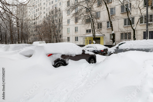 Snow-covered cars in parking after snowfall in winter. 