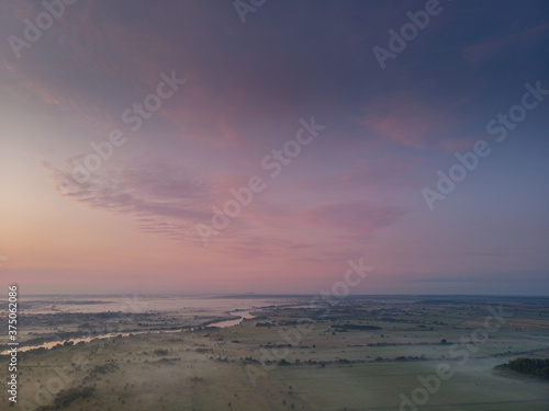 cloudy beautiful soft dawn or sunset, horizontal photo 16: 9, photos from the air, low sun rays pierce low clouds
