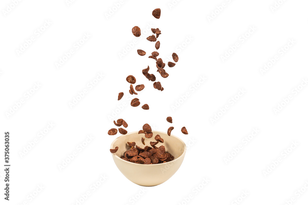 Chocolate corn flakes falling to the white bowl isolated on white. Motion. Chocolate corn flakes falling to the white bowl isolated on white. Motion.