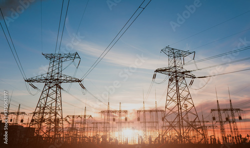 High-voltage power lines at sunset or sunrise. High voltage electric transmission tower