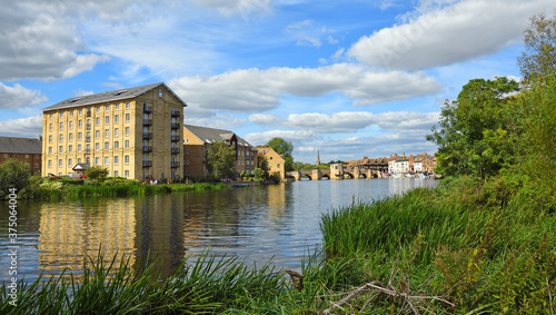 The River Ouse at St Ives Cambridgeshire with the Old Mill, historic bridge and river port.