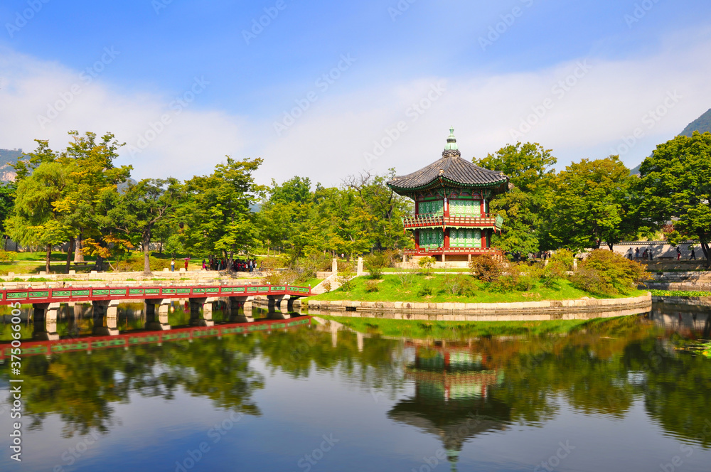 Beautiful view of traditional Hyangwonjeong pavilion among lush green trees with amazing water reflection in the pond at late summer, Gyeongbokgung, Seoul, South Korea Beautiful view of traditional Hyangwonjeong pavilion among lush green trees with amazing water reflection in the pond at late summer, Gyeongbokgung, Seoul, South Korea