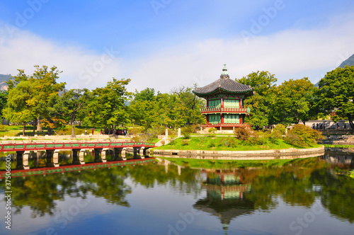 Beautiful view of traditional Hyangwonjeong pavilion among lush green trees with amazing water reflection in the pond at late summer, Gyeongbokgung, Seoul, South Korea