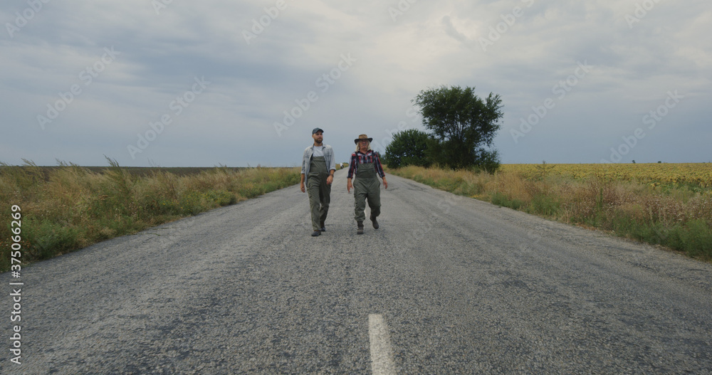 Anonymous farmers walking on road and talking