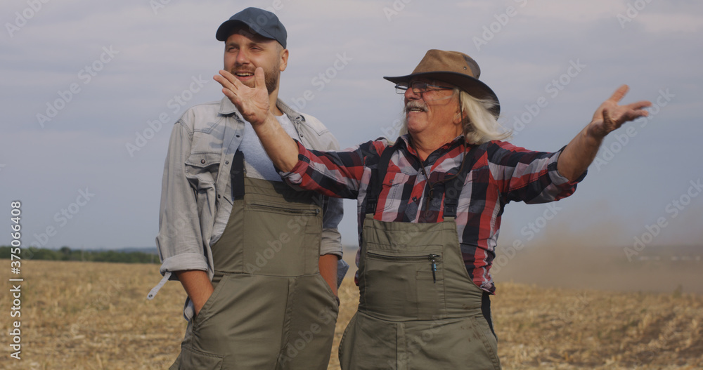 Naklejka premium Positive farmers dispersing soil in air