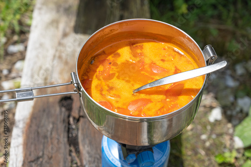 Tomatensuppe wird auf Gaskocher zubereitet, Schweiz photo