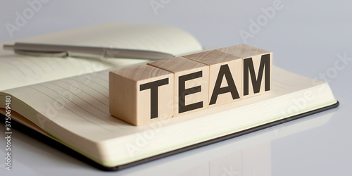 The TEAM sign on a wooden block on notebook background