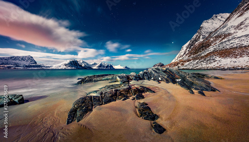 Full moon illuminates the exotic Haukland beach, Norway, Europe. Mystical night sescape of Norwegian sea. Awesome spring view of Lofoten Islands archipego.  Life over polar circle.. photo