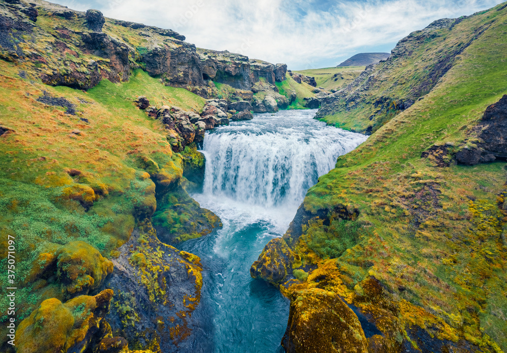 Breathtaking morning scene of waterfall on Skoga river. Aerial summer view from the tourist trek from famous Skogafoss waterfall to the top of the river, Iceland, Europe.